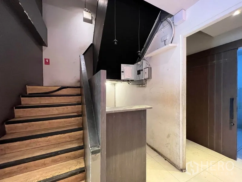 Shophouse for rent - Internal staircase with wood steps beside a small counter and storage nook.