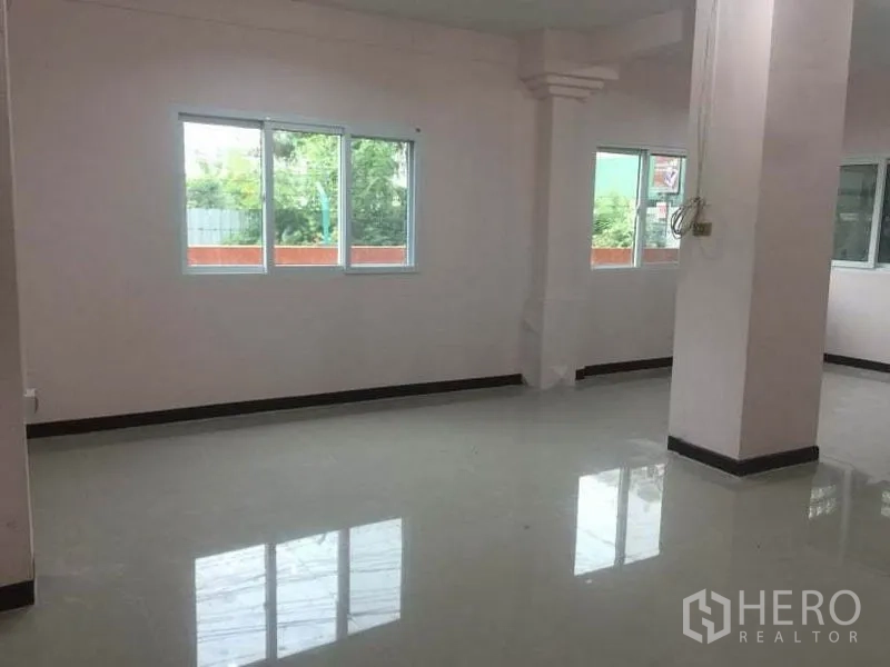 Detached House for rent in Chatuchak, Bangkok - Light-filled corner of living space with several windows and pale tile flooring.