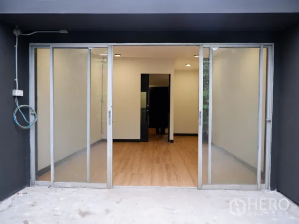 Home Office for sale in Bang Rak, Bangkok - Ground-floor entry with wide sliding glass doors opening to a bright workspace with wood floors.