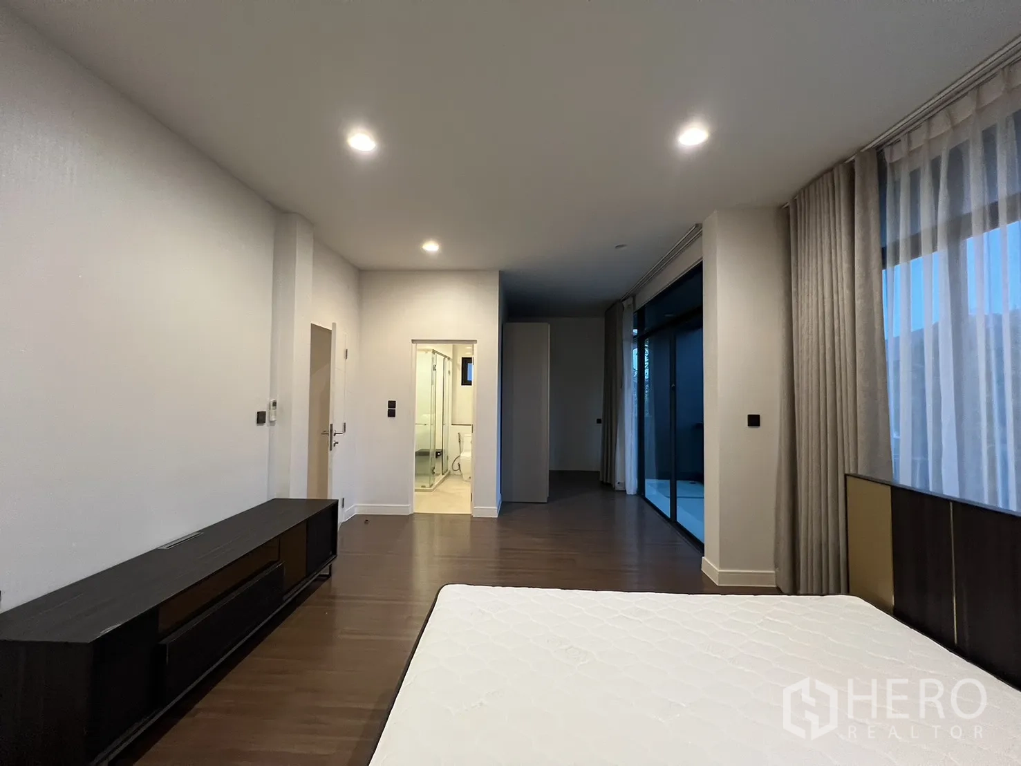 Detached House for rent or sale in Bang Kapi, Bangkok - Master bedroom with balcony access and wide windows.