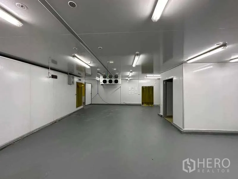 Warehouse for rent in Khlong Luang, Pathum Thani - Sterile production room with gray epoxy floor, cooling fans and strip curtains.