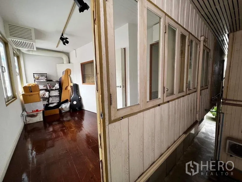 Townhouse for rent - Side corridor with windows, storage shelves and polished wood floor.