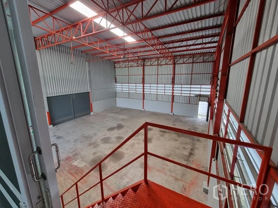 Warehouse for rent in Lam Luk Ka, Pathum Thani - View from the mezzanine staircase over the high-bay warehouse and steel roof structure.