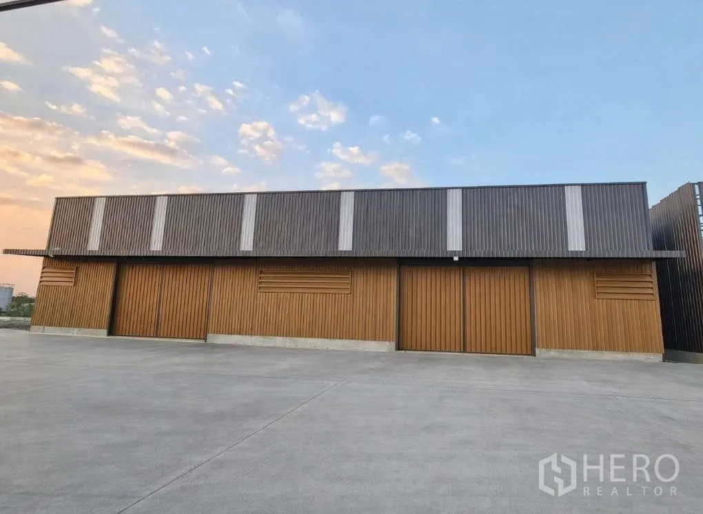 Warehouse for rent in Bang Khen, Bangkok - Front elevation of a warehouse with wide sliding doors and a paved apron.