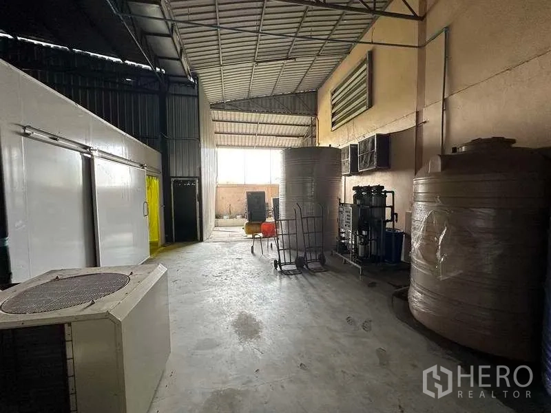 Warehouse for rent in Khlong Luang, Pathum Thani - Utility zone with large water storage tanks beside insulated rooms.
