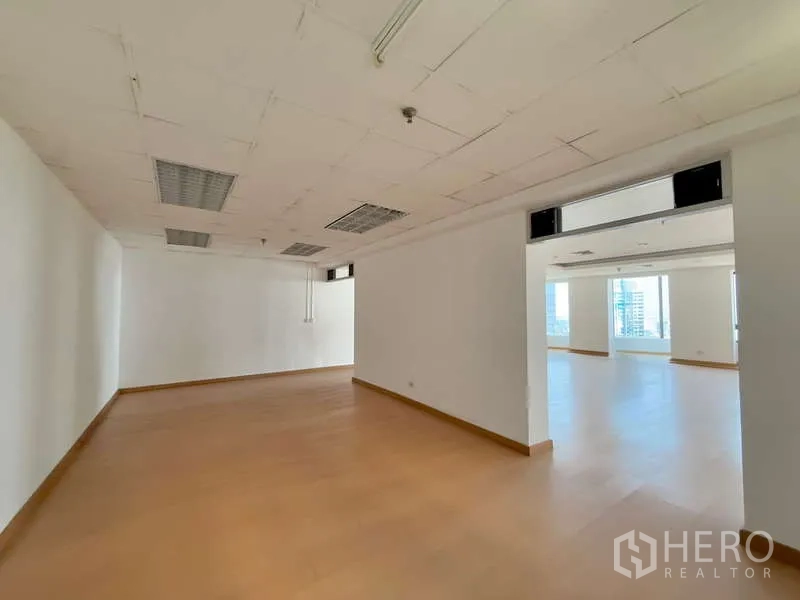 Office Space for rent in Chatuchak, Bangkok - Open corridor linking two office zones with drop ceiling lights and laminate flooring.
