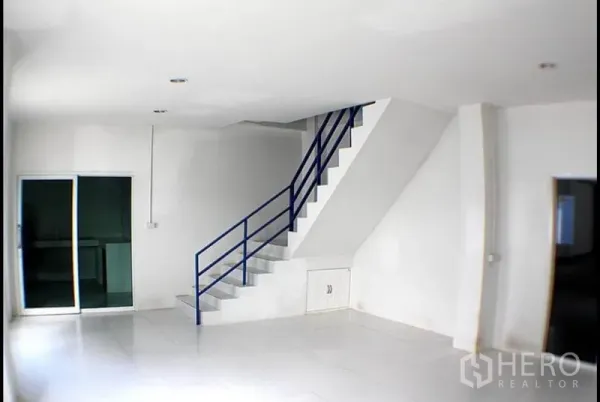 Factory for rent in Pak Kret, Nonthaburi - Bright tiled office area with staircase and sliding glass door inside the factory.
