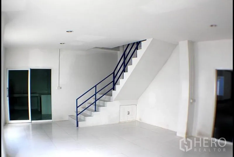 Factory for rent in Pak Kret, Nonthaburi - Bright tiled office area with staircase and sliding glass door inside the factory.