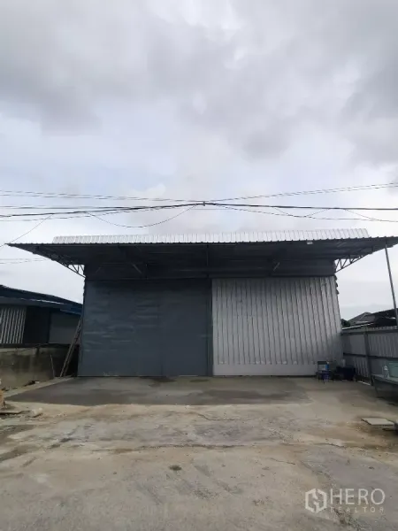 货栈 出租在Min Buri, Bangkok - 曼谷民武里仓库外立面，宽幅金属推拉门与带顶装卸区。