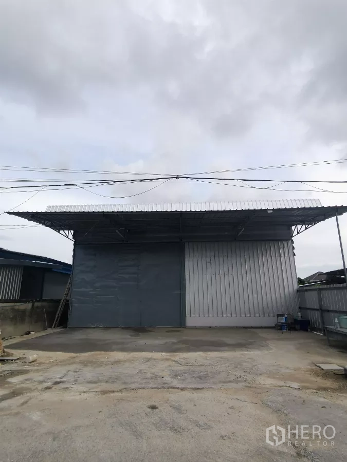 货栈 出租在Min Buri, Bangkok - 曼谷民武里仓库外立面，宽幅金属推拉门与带顶装卸区。