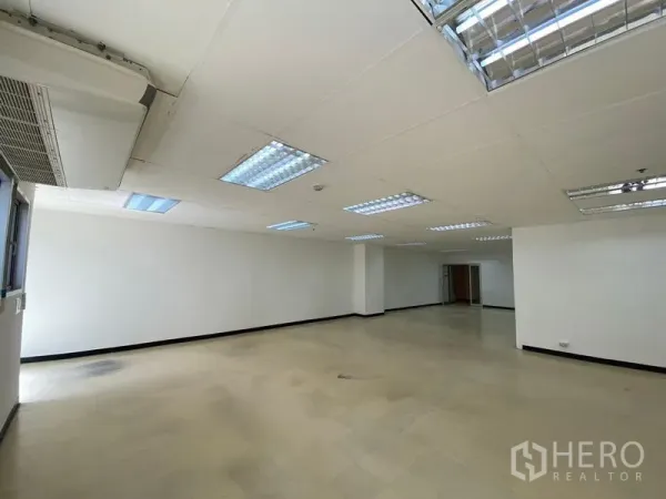 Office Space for rent in Watthana, Bangkok - Spacious office floor with multiple ceiling light panels and wall-mounted air-conditioning.