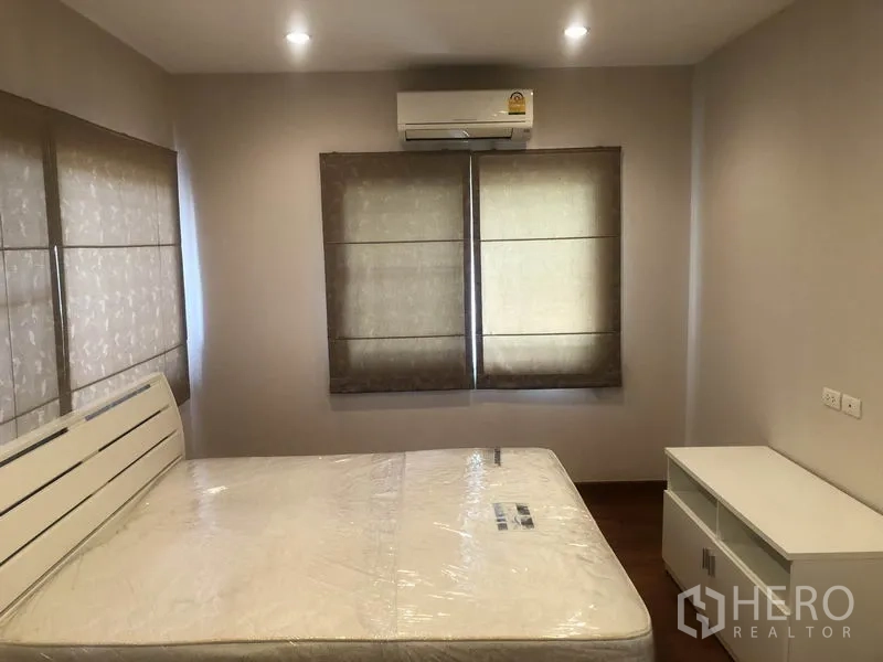 Detached House for rent or sale in Pak Kret, Nonthaburi - Secondary bedroom with two windows, air conditioning and minimalist furniture.