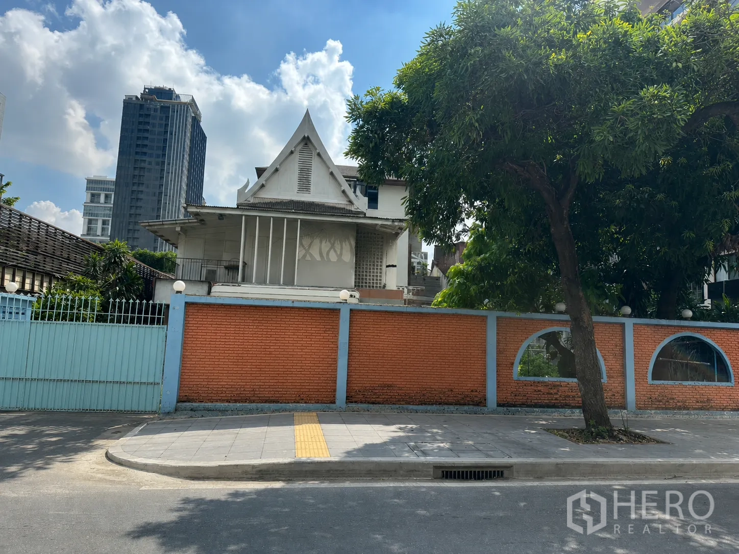 独栋房屋 for rent in Watthana, Bangkok - 街景视角，物业位于砖墙与蓝色金属大门之后。