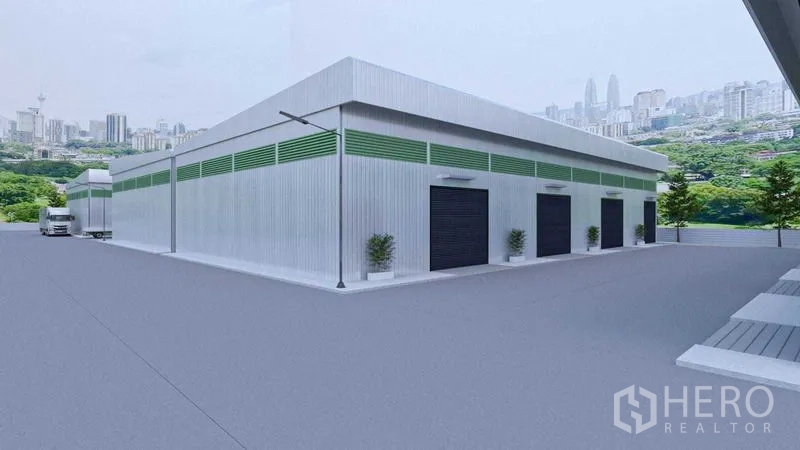 Warehouse for rent in Bang Phli, Samut Prakan - Corner perspective of a metal warehouse with loading bays and truck access on a broad paved yard.