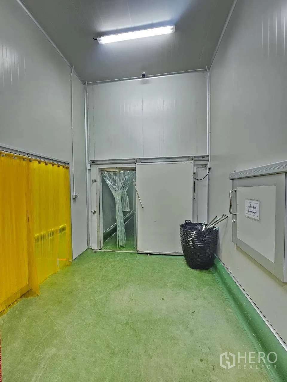 Factory for rent in Mueang Samut Sakhon, Samut Sakhon - Entrance zone with green floor and twin plastic-strip doorways.