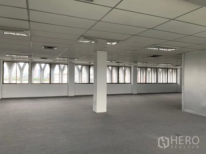 办公空间 出租在Ratchathewi, Bangkok - 拐角办公区域，宽幅窗户与外立面拱形框架，吊顶灯具齐全。