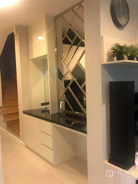 Detached House for rent or sale in Bang Kapi, Bangkok - Living area feature wall with mirrored panels beside the staircase.