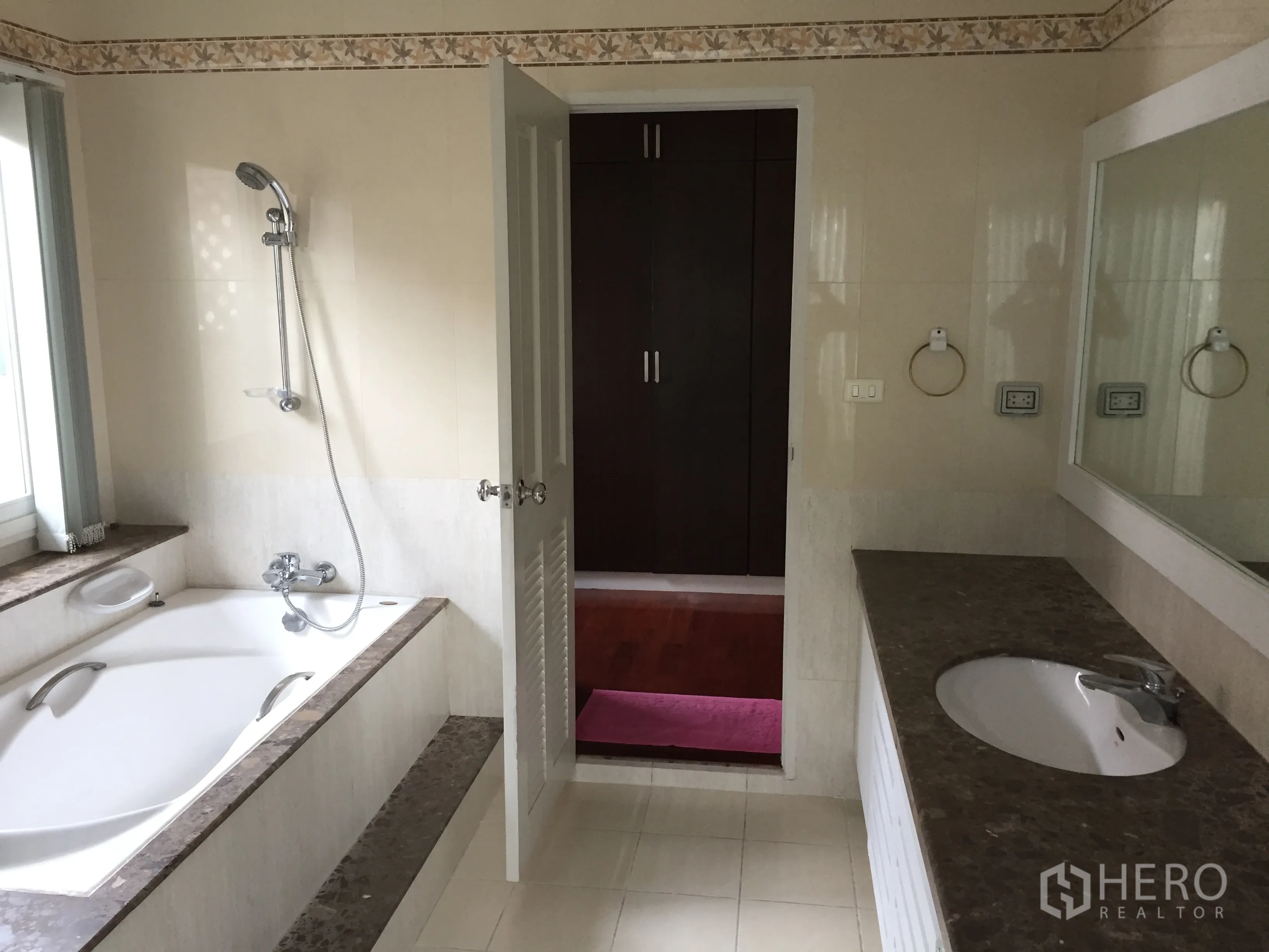 Detached House for rent or sale in Lat Phrao, Bangkok - Bathroom with built-in bathtub, separate shower and a long stone-top vanity.