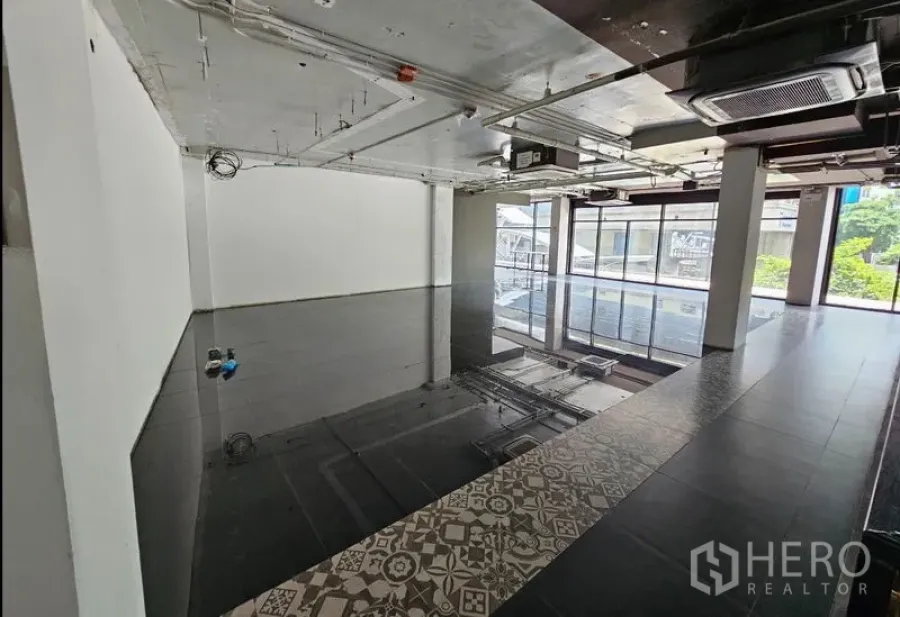Retail Space for rent in Bang Rak, Bangkok - Corner retail unit with glass frontage, ducted air-conditioning on an exposed ceiling, and abundant natural light.