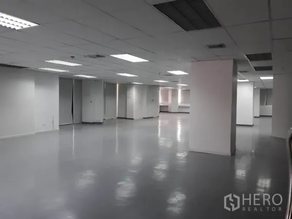 Office Space for rent in Huai Khwang, Bangkok - Wide work area with structural columns, bright fluorescent lighting and white walls