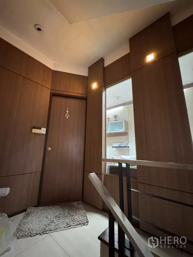 Shophouse for rent in Bang Rak, Bangkok - Compact landing with wood panel walls, doorway, and illuminated display niches.