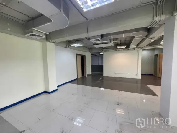办公空间 出租在Ratchathewi, Bangkok - 可灵活分隔的工作区，双色地砖，外露空调管道，通往私密房间的门。