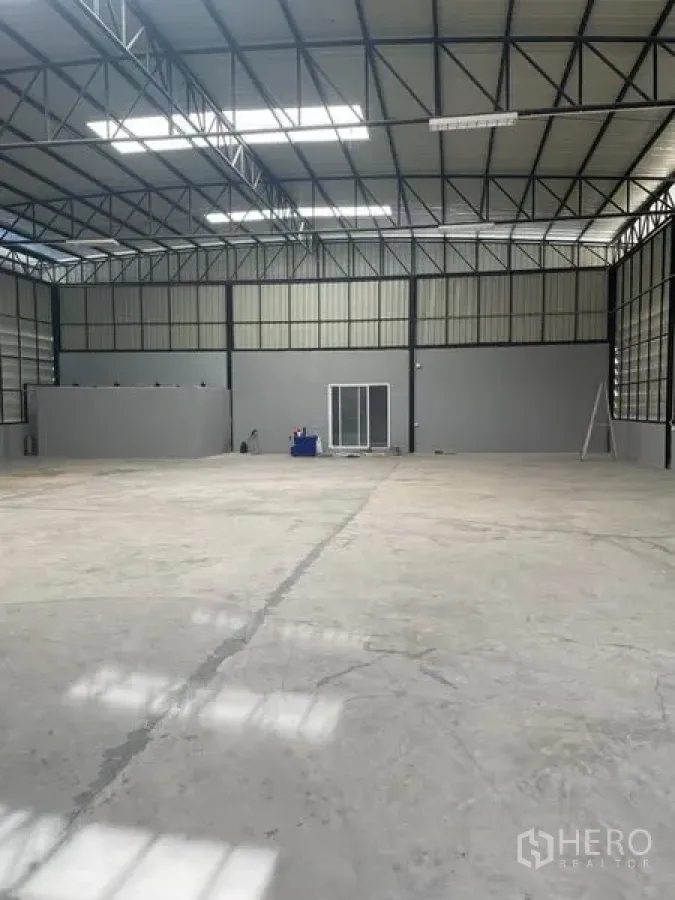 Warehouse for rent in Saphan Sung, Bangkok - Open-plan warehouse with high roof, smooth concrete floor and a glass-fronted internal office.