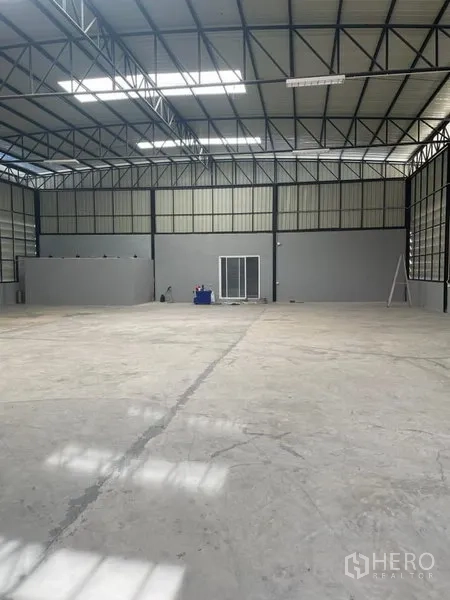 Warehouse for rent in Saphan Sung, Bangkok - Open-plan warehouse with high roof, smooth concrete floor and a glass-fronted internal office.