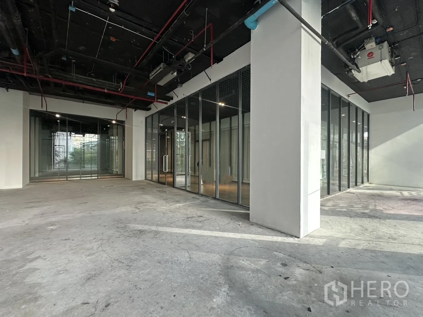 Retail Space for rent in Khlong Toei, Bangkok - Spacious shop unit with multiple glass doors and an adjacent glass-partitioned room.