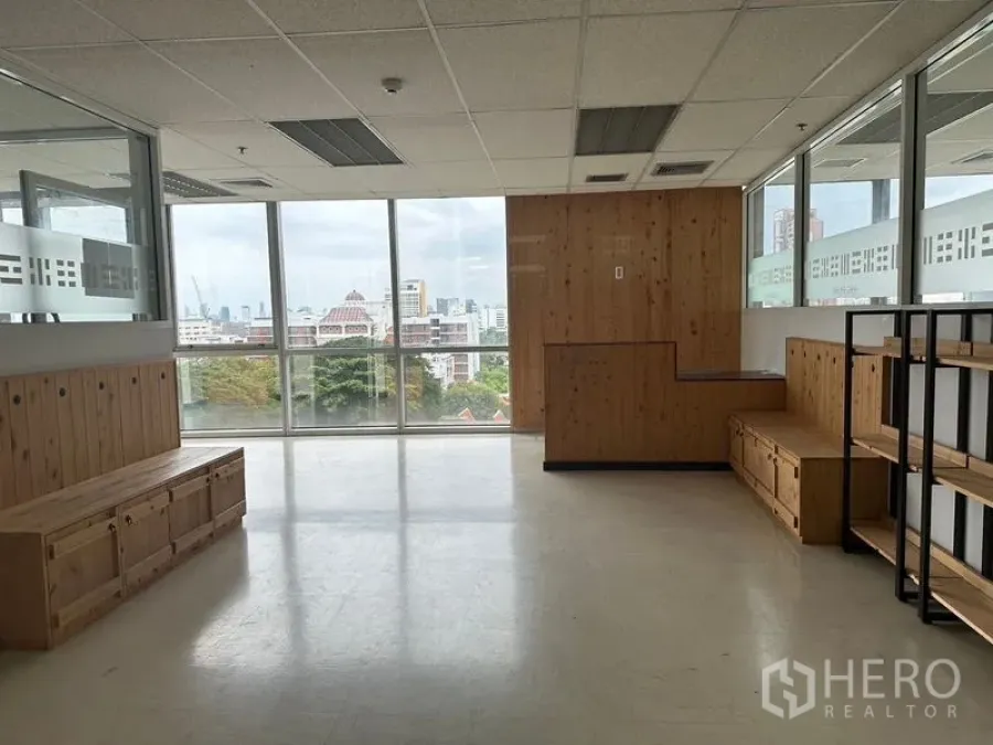 办公空间 出租 - 办公室等候区，木质座椅与置物架，通过大窗可见城市景色。