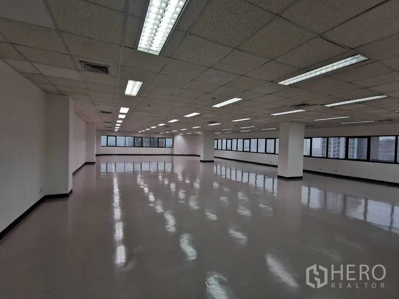Office Space for rent in Watthana, Bangkok - Spacious open-plan office floor with polished floors, drop ceiling lights, and long ribbon windows offering city views.