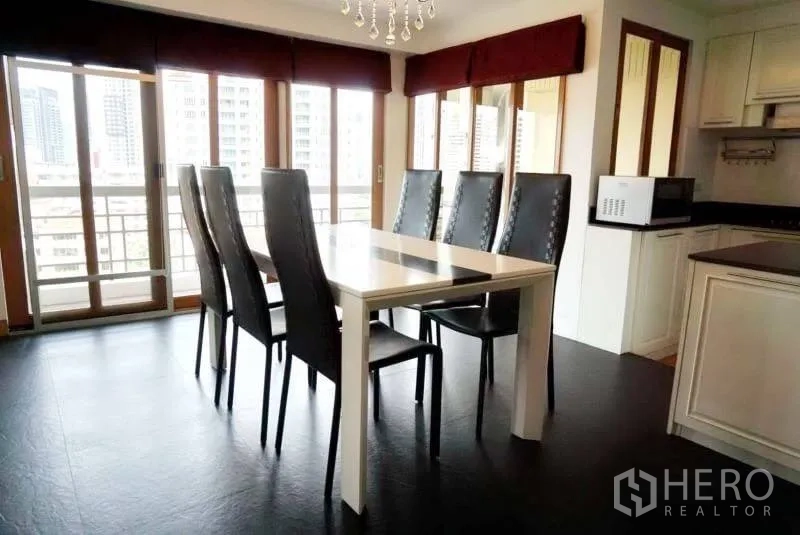 Condominium for rent in Watthana, Bangkok - Dining table for six beside floor-to-ceiling windows with city views and balcony access.