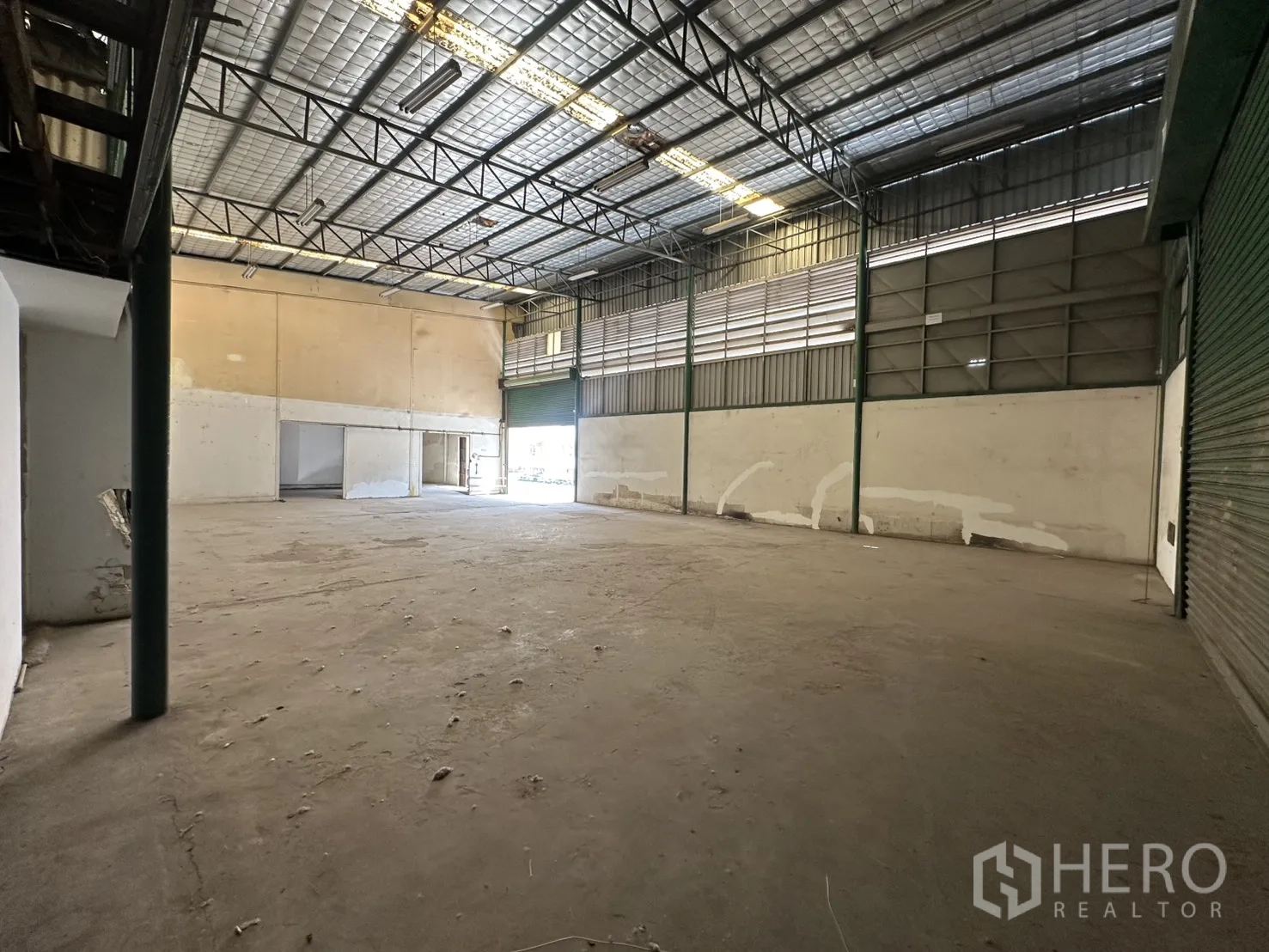 Warehouse for rent in Suan Luang, Bangkok - High-bay space with louvered side walls, skylight panels, and large shutter access for vehicles.