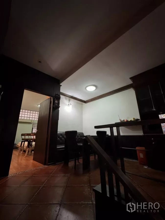 Shophouse for rent in Bang Rak, Bangkok - Low-lit lounge and dining zone with leather seating and terracotta tiles.