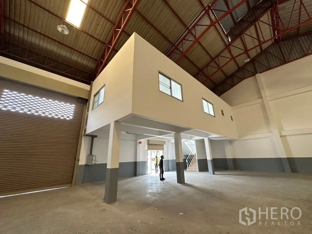 Factory for rent in Bang Sao Thong, Samut Prakan - Mezzanine office above loading zone beside tall roller shutter inside the factory.