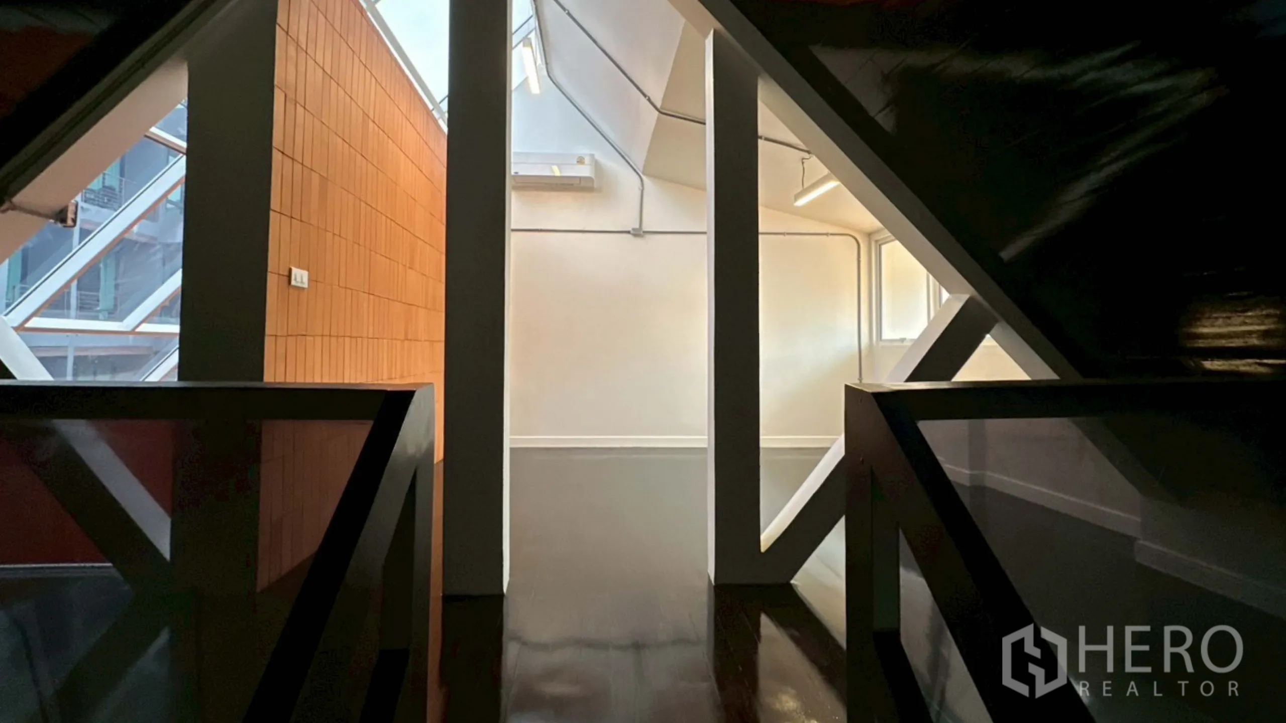带办公室的家 出租在Watthana, Bangkok - 坡屋顶下的夹层步道，梁架与天窗采光。