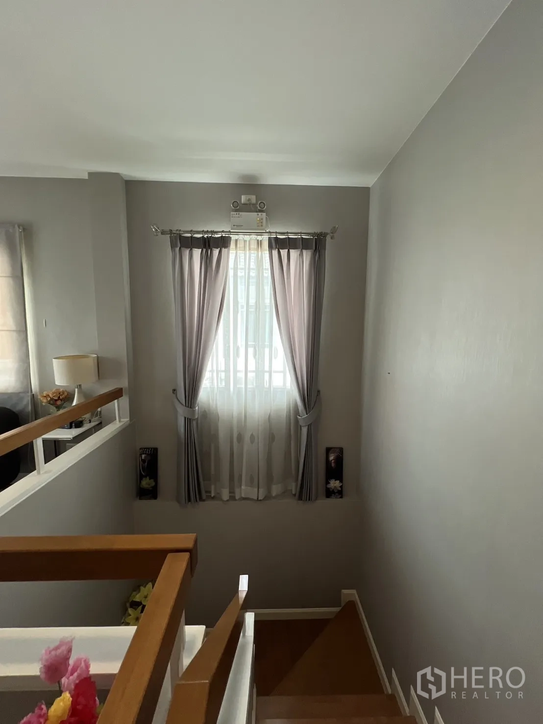 Detached House for rent in Bang Kapi, Bangkok - Staircase landing with a curtained window bringing in natural light.