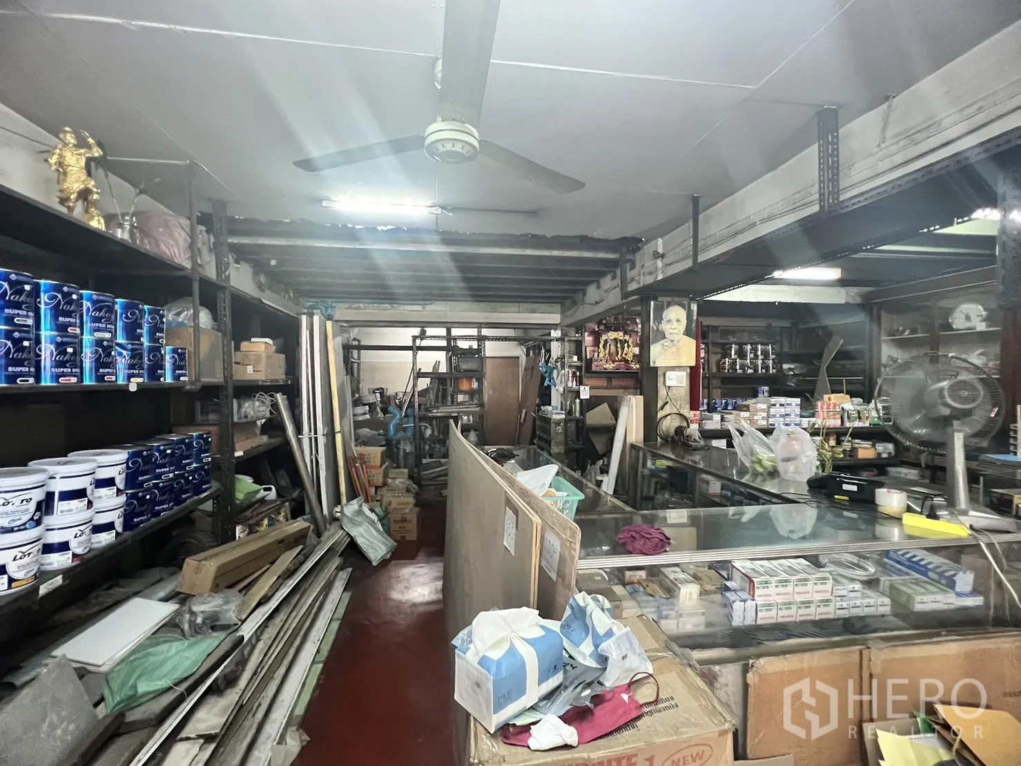 零售空间 出租在Watthana, Bangkok - 主通道设长柜台、吊扇，钢制货架上摆满涂料