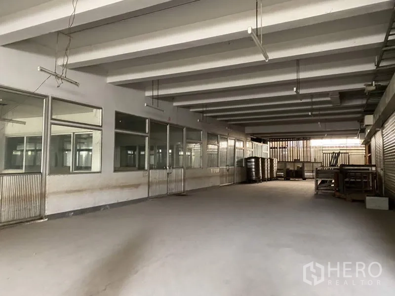 工厂 for sale in Khlong Luang, Pathum Thani - 室内服务区，带内窗与后部卷闸门。