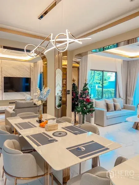 Detached House for sale in Bang Kapi, Bangkok - Bright open-plan dining and living area with sculptural chandelier, large windows and marble-look flooring.