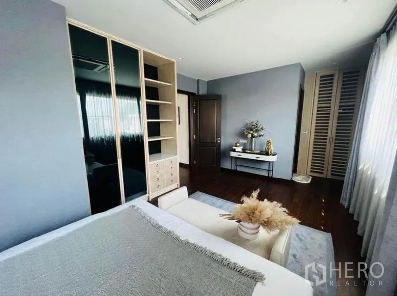 Detached House for rent or sale in Watthana, Bangkok - Secondary bedroom showing wardrobe wall, console table and soft natural light.
