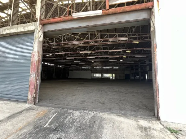 Factory for rent in Phra Pradaeng, Samut Prakan - Wide roller door entrance opening to a spacious warehouse interior.