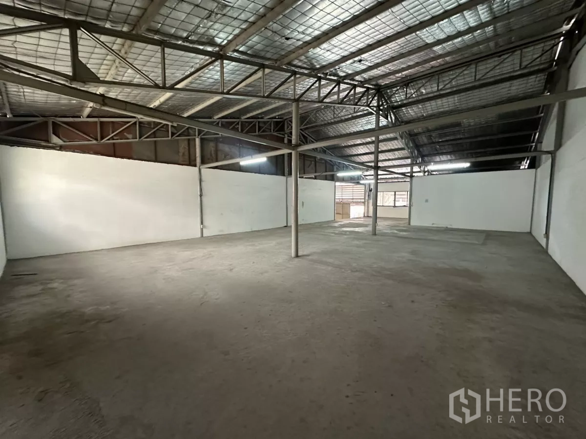 Warehouse for rent in Suan Luang, Bangkok - Open warehouse space with insulated roof, steel beams and white partition walls.