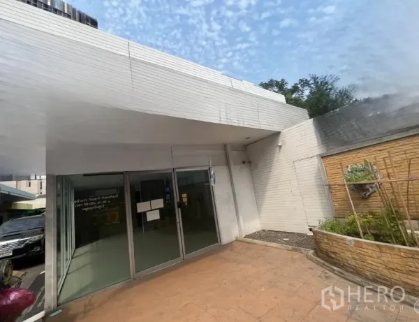 Retail Space for rent in Khlong Toei, Bangkok - Angled view of storefront with terra-cotta walkway and raised planter bed.