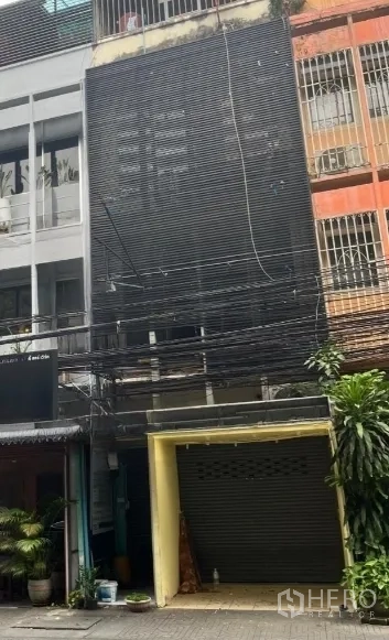店屋 for rent in Khlong Toei, Bangkok - 店屋外观另一角度，深色立面与关闭的卷闸门。