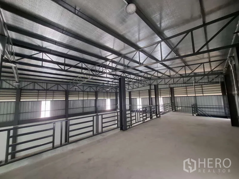 Warehouse for rent or sale in Bang Phli, Samut Prakan - Upper mezzanine level with steel trusses and safety railings for extra storage.