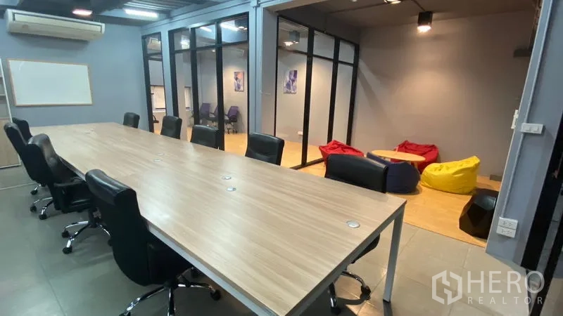Office Space for rent in Sathon, Bangkok - Conference table facing a beanbag lounge within a glass-partitioned Bangkok office.