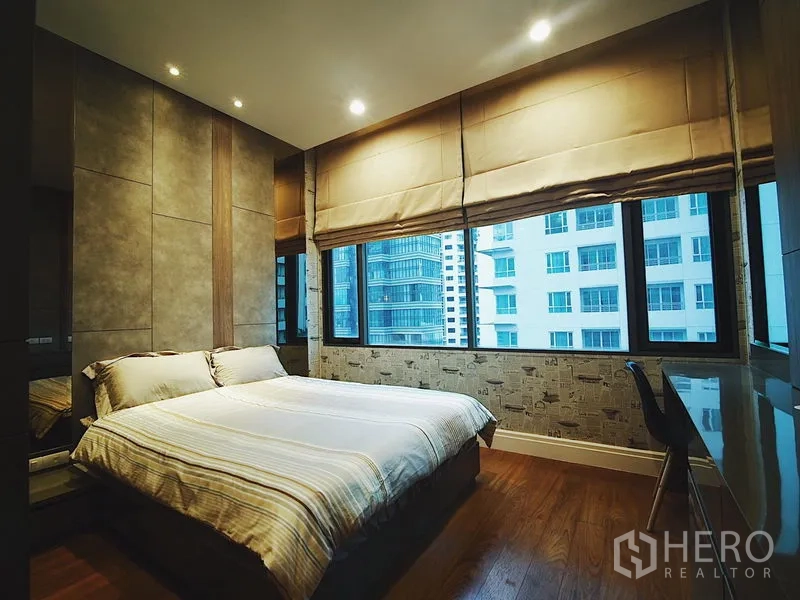 Condominium for rent in Khlong Toei, Bangkok - Bright bedroom with corner windows, city views and double bed with blinds.