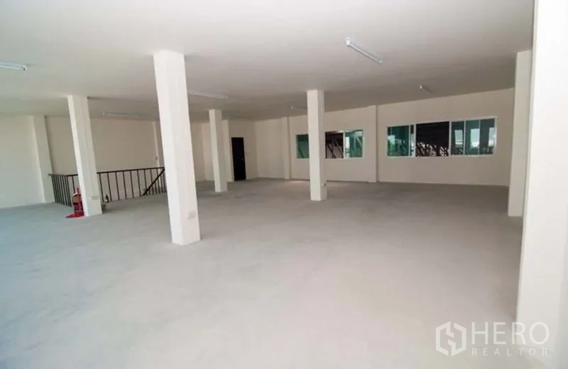 Factory for rent in Bang Sao Thong, Samut Prakan - Open-plan office floor with concrete columns and fluorescent lighting.