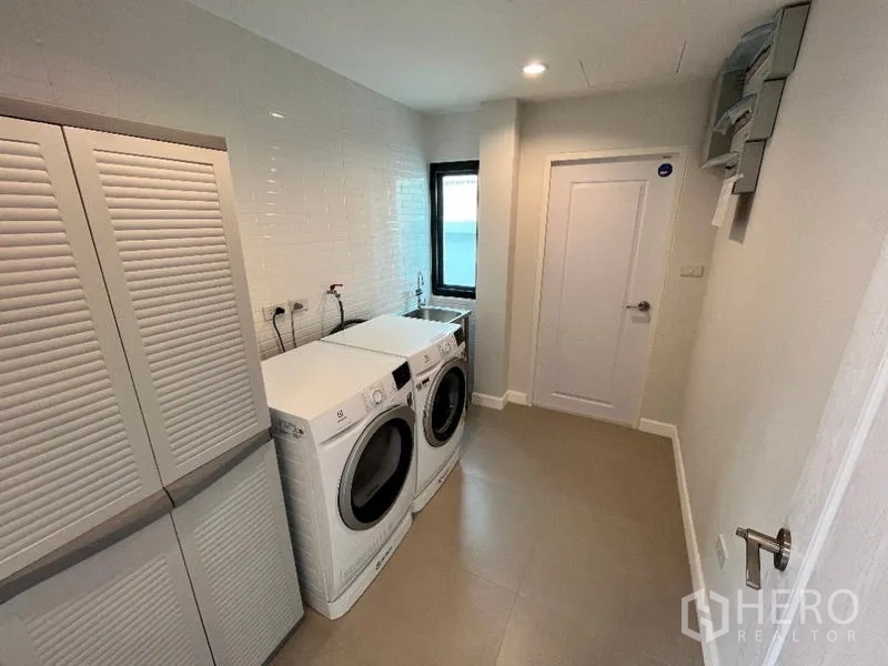 Detached House for rent in Phaya Thai, Bangkok - Laundry room with front-loading washer and dryer plus storage cabinets.
